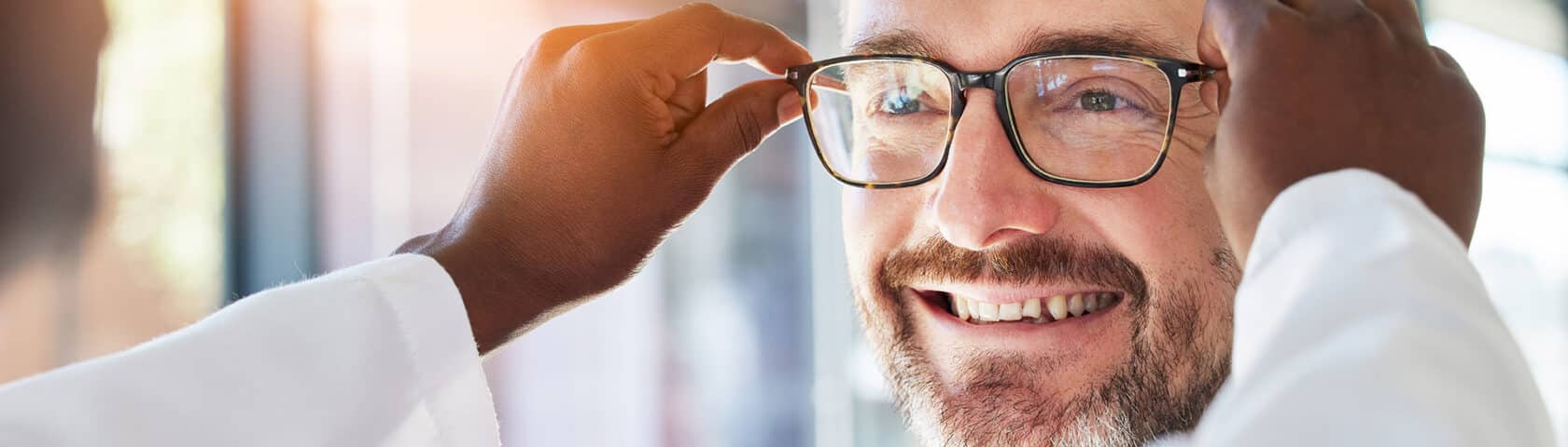 Optometry, Doctor And Glasses For Happy Man At A Clinic For Vision, Healthcare And Help With Eye Care. Smile, Retail And A Male Customer With An Optometrist And Eyewear During A Medical Consultation