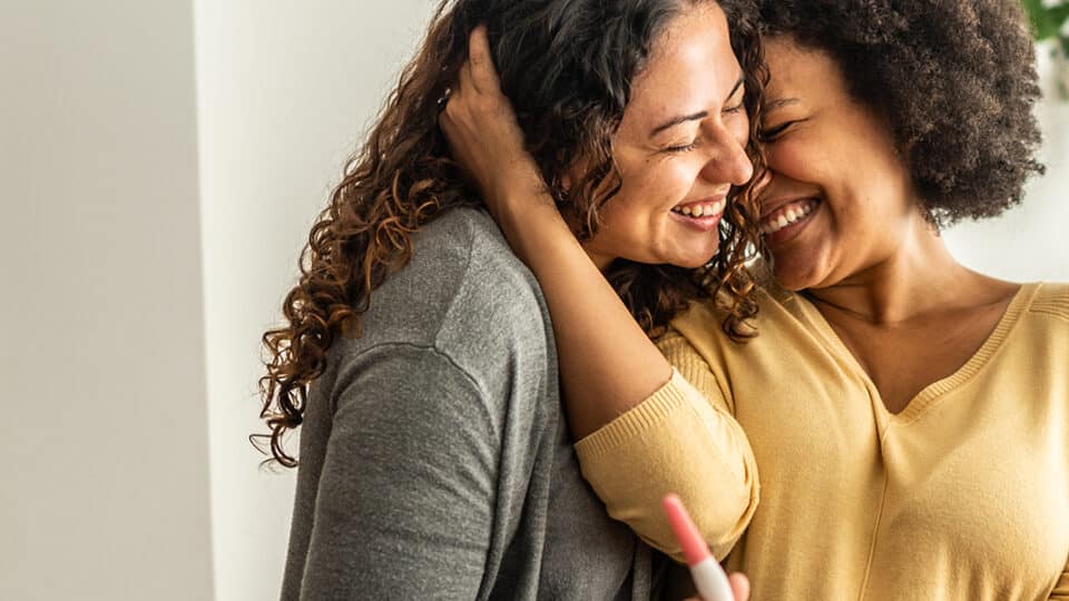 Lesbian Couple Holding A Pregnancy Test At Home