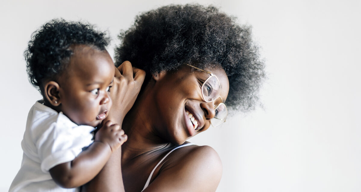 Mother and young child smiling together.