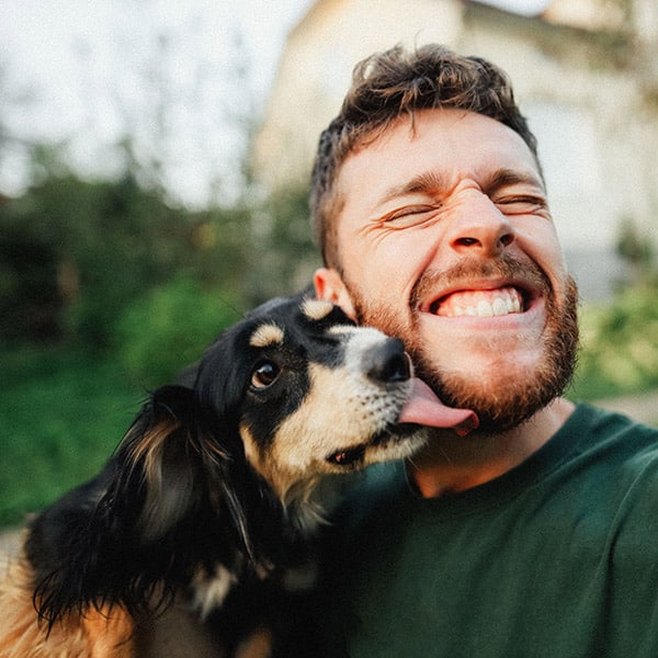 Young Man Is Playing With A Dog And Do Selfie