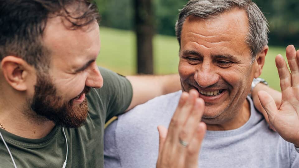 Man And Son Exercising In Park Together