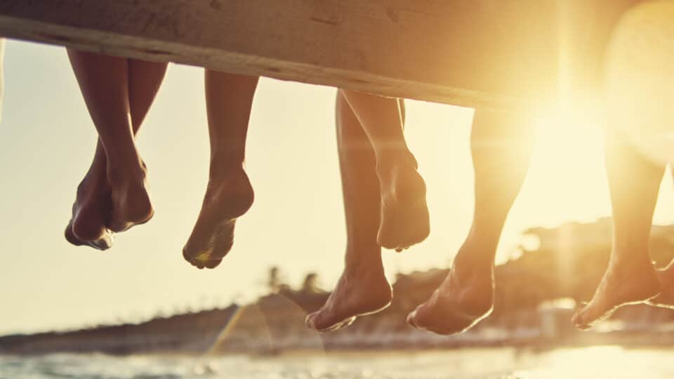 Family Sitting On Pier By The Sea